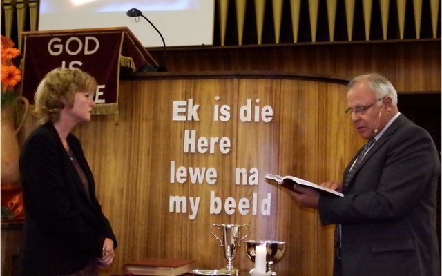 Regs is ds Dirk van Dyk besig met die bevestiging van dr Lisel Joubert as NG-leraar