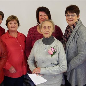 Voor staan Betsie van der Merwe trots saam met ‘n deel van die Bietoubossers se bestuur, met vlnr Enna Lotz, Aletta Löchner, Riana Botha, Carina de Waal, Marie de Jager en Leonie Botha.