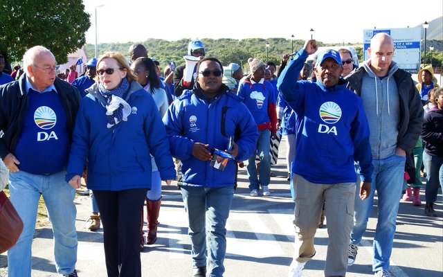 DA-leiers tydens ‘n vreedsame optog saam met die Wes-Kaapse Premier, Helen Zille met singende en dansende ondersteuners van Masakhane agter hulle.  Voor vlnr is  Rdl Dudley Coetzee (Wyk 11),  Helen Zille,  Masizole Mnqasela (Lid van die Provinsiale Parlement),  Andrew Komani (Wyk 1)  en  dr. Michael Cardo (Lid van die Parlement).