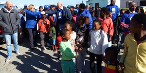 Selfs kinders het opgewonde en al dansende aan Premier Helen Zille se optog in Masakhane se strate deelgeneem. Tweede van links gee Premier Zille en Rdl Dudley Coetzee mekaar ‘n handdruk.