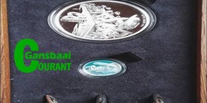 Die gemonteerde R2 en 2½c silwermuntstukke, met dolosafdrukke daarop, waarmee Aubrey Kruger enkele weke voor sy afsterwe deur die Suid-Afrikaanse Munt vereer is.  
