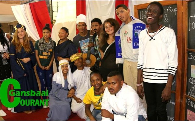 Gansbaai Academia en die dorp se sjefs het vanjaar  hande gevat vir hul jaarlikse Voedselfees.  ‘n  Verwelkomingsgroep wat elk van die tien lande verteenwoordig het, het gaste ingewag.  Van links Chanelle Perumal,  Lehanna Louw,  Marsha Lee Boshoff,  Nazli Ellis,  Geolin Baartman, Divan  Classen, Aimelize Geerdtse, Keenan Michells en Analo Yawa. Voor sit Megan Pieterse, Chrizano Wildschut en Jason Groenewald.