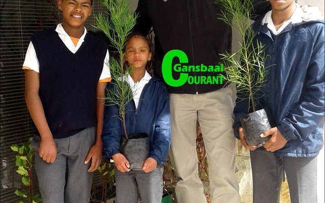 Leerders van die Hulpbronklas van Gansbaai Primêr neem hul bome vir boomplantweek in ontvangs. Voor vlnr Gereldo Gouws, Louise Fortuin en Rubin Jacobs, met Johan Greyling van Overberg Agri, Stanford agter hulle.