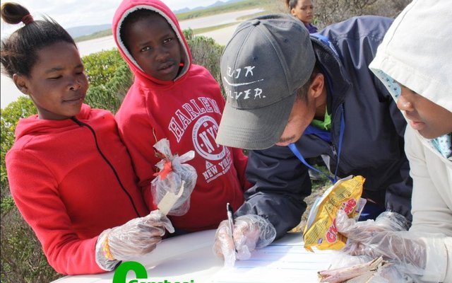 Die  Deep Blue groep van Masakhane bring hul “vangs” om aangeteken te word. Van links glimlag Inge Mtonga, Mihlali Ndongeni, Devan Nevan (Overstrand Munisipaliteit) en Thina Ntsunte. 