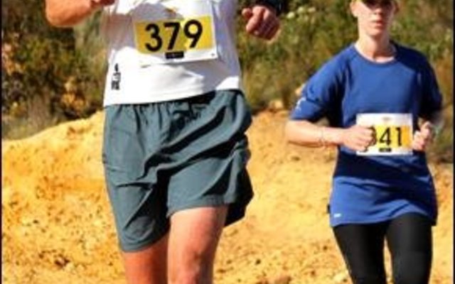 Christoff Fourie en Monique Janse van Rensurg nader die waterpunt.  Hulle het onderskeidelik 7de en 9de geëindig in Sondag se 12km wedloop.  