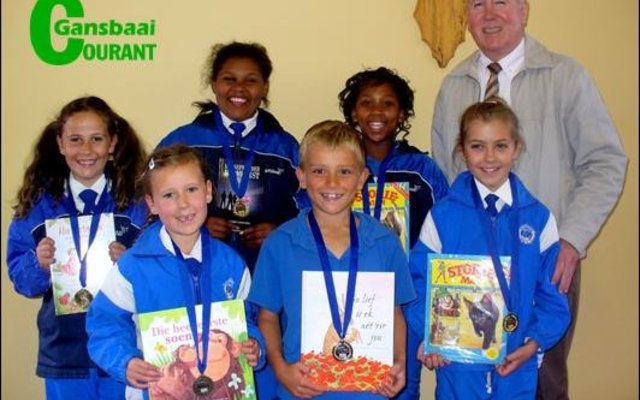 Op die foto oorhandig die skoolhoof, mnr. Eben van der Merwe dit aan die trotse groepie.  Agter van links Carla Oosthuizen (Gr 3), Jay-Andra Pieters (Gr 6), Nevellia October (Gr 5) en mnr. Eben van der Merwe.   Voor van links Anke Oosthuizen (Gr 1), Stefan Stieger (Gr 2) en Lara Strydom (Gr 4).