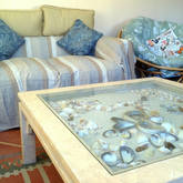 The rustic beach theme and shell table brings the seaside vibe into the cottage