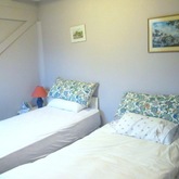 Bedroom 2 has twin beds and a pleasing floral cottagy feel
