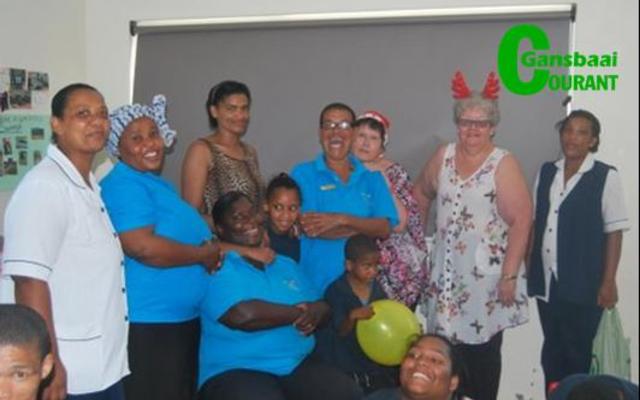 Vanjaar is die personeel van Gansbaai Elimhuis saam met die kinders met geskenke verras. Voor sit Sanna Wessels en agter vlnr staan Cornelia Johannes, Nomputhomo Phakade, Nicolene Baardman, Mariana Visagie, Marie Reid (weldoener), Hanlie Strydom (mede-weldoener) en Eldoret Newman.      