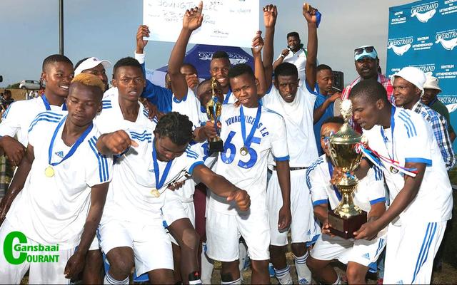 Stanford Young Tigers FC pump their fists in the air in exultation and hold the winning trophy and cheque aloft with great pride after being crowned the undisputed winners in Saturday’s soccer grand finale.
