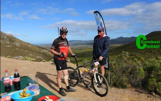 Heinrich Smith van Franskraal luier ‘n bietjie by die waterpunt om die pragtige uitsig en verversings te geniet, terwyl Du Toit Kotzé sy fiets vashou.