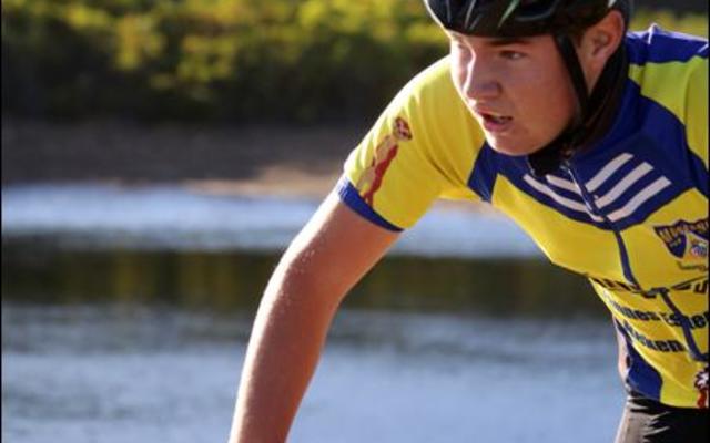 Een van die eerste junior fietsryers jaag oor die damwal by Farm 215.