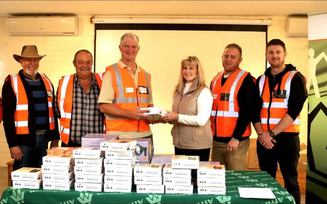 Gansbaai was die eerste dorp in Suid-Afrika wat tegnologies gevorderde digitale radios ontvang het om misdaadbekamping te vergemaklik.  Hier oorhandig Elmarie van Dalen, voorsitter van AfriForum se Overstrand-tak die radios amptelik aan Mark Collings, voorsitter van die Groter Gansbaai Buurtwag.  In hulle splinternuwe glimbaadjies staan die buurtverteenwoordigers van links:  Johan Pieterse (Perlemoenbaai), Kobus van Staden (Franskraal), Cassie Smith (Kleinbaai), Mark (De Kelders) en Elmarie, Hugh-Daniel Grobler (Gansbaai – ook ondervoorsitter van die Groter Gansbaai buurtwag) en Johan du Toit (Pearly Beach). 