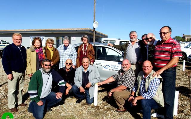 ‘n Groep van die opgewonde patrollielede van Franskraal Buurtwag tydens die opening van hulle beheerkamer voor een van hulle patrollievoertuie.