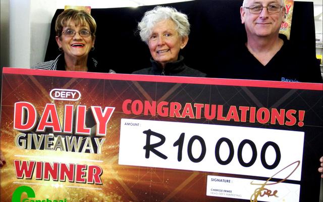 Dis mos hoe ‘n R10 000 glimlag moet lyk. Claudette Barnes ontvang haar prys van Corrie Kotze, Defy se verteenwoordiger (links). Bayview Meubels se eienaar, Jan Barnard (regs) glimlag heel tevrede.