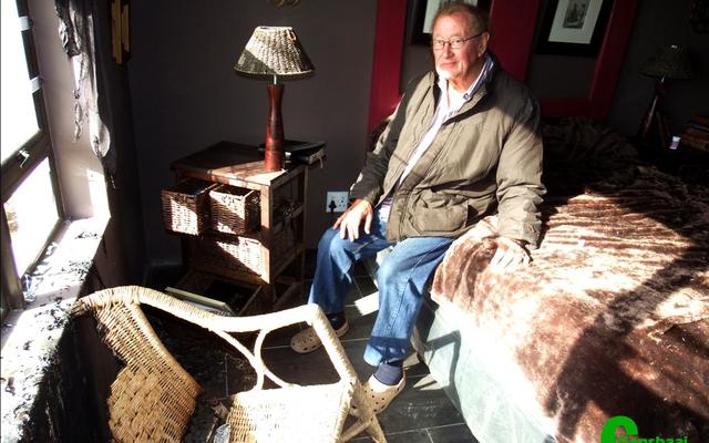 André Vorster sit moedeloos op hulle bed in die roetgevulde slaapkamer, met sy vrou, Judith, se verbrande rottangstoel voor hom en die venstertjie wat uitgeslaan is, skuins bokant die stoel.