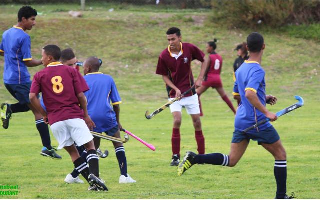 Malin Kaptein (middel) van die Sharkies se hokkiespan lei hier ‘n aanval op Eben Dönges se spelers.