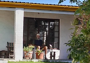 Die oupa sit op die stoep